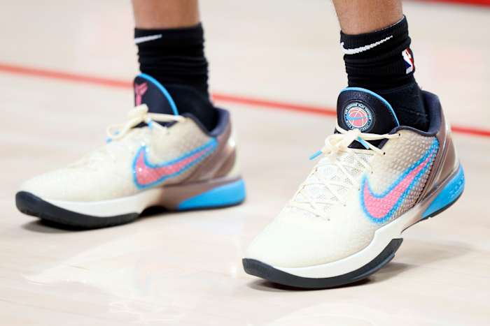 View of white, pink, and blue Nike Kobe shoes.