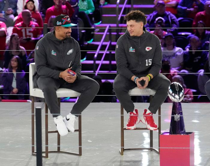 Jalen Hurts and Patrick Mahomes speak on stage during a media event.