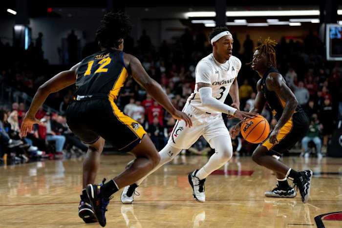 Cincinnati Bearcats guard Mika Adams-Woods (3) dribbles as East Carolina Pirates guard Javon Small (12) guards him in the first half of the NCAA men s basketball game at Fifth Third Arena in Cincinnati on Wednesday, Jan. 11, 2023. Ncaa Basketball Eastern Carolina Pirates At Cincinnati Bearcats