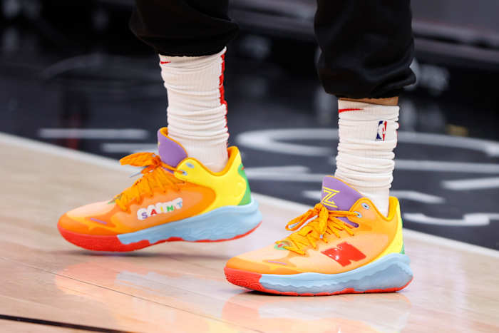 View of orange and purple New Balance shoes.