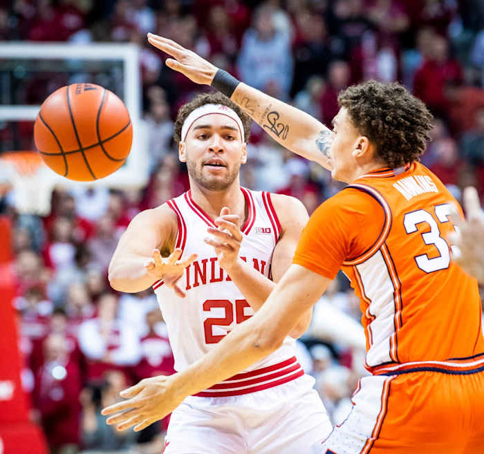 Indiana's Race Thompson (25) passes through the arms of Illinois' Coleman Hawkins (33) during the first half of the Indiana versus Illinois men's basketball game.
