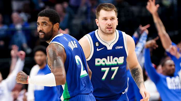 Mavericks guard Kyrie Irving celebrates a basket with teammate Luka Doncic