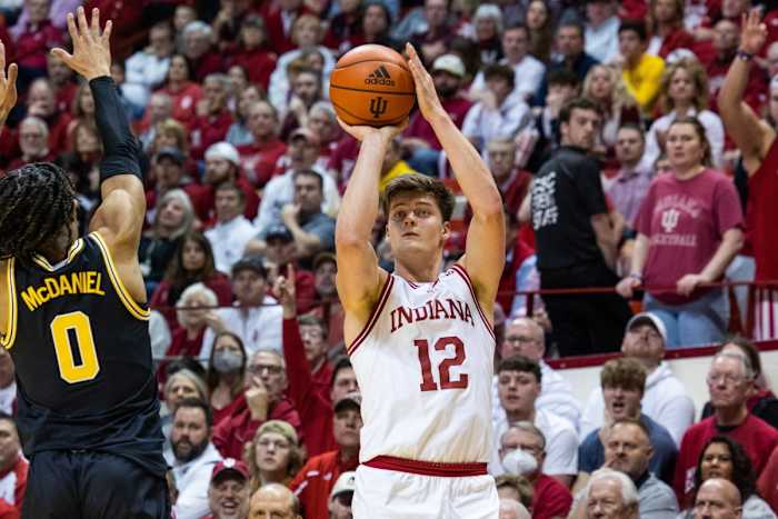 Miller Kopp (12) shoots the ball while Michigan Wolverines guard Dug McDaniel (0) defends.