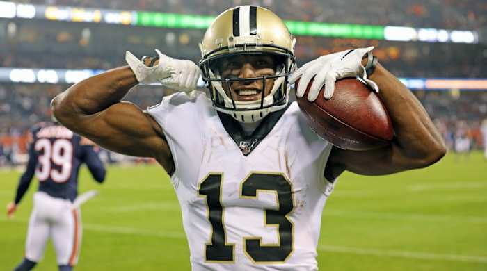 Saints receiver Michael Thomas flexes and smiles after catching a touchdown during a game against the Bears.