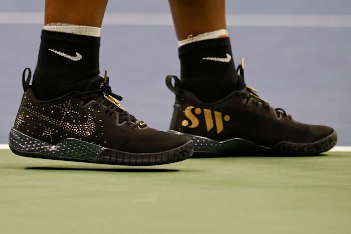View of Serena Williams' black and gold Nike shoes.