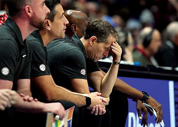 Arkansas Razorbacks head coach Eric Musselman hangs his head on the bench late in the second half of a loss against the Texas A&M Aggies.