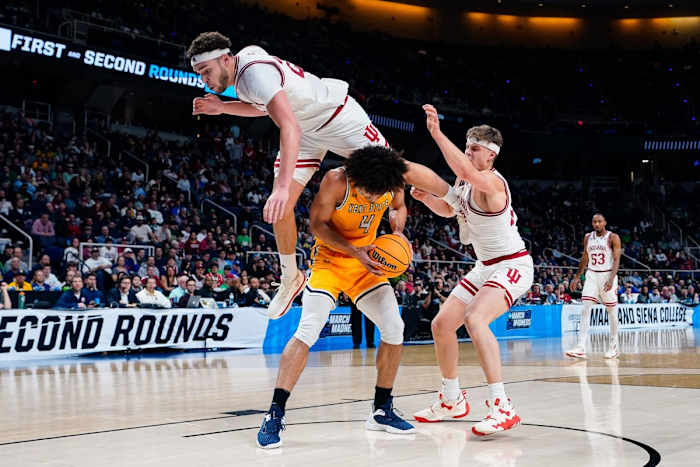 Race Thompson (25) falls over the back of Kent State Golden Flashes forward Chris Payton (4) as forward Miller Kopp (12) defends.