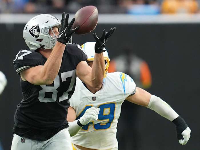 Dec 4, 2022; Paradise, Nevada, USA; Las Vegas Raiders tight end Foster Moreau (87) makes a catch ahead of Los Angeles Chargers linebacker Drue Tranquill (49) during the first half at Allegiant Stadium. Mandatory Credit: Stephen R. Sylvanie-USA TODAY Sports
