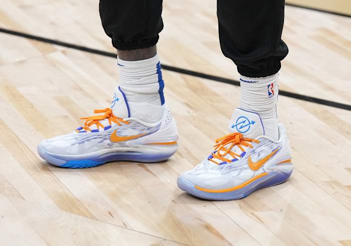 View of white, orange, and blue Nike shoes.