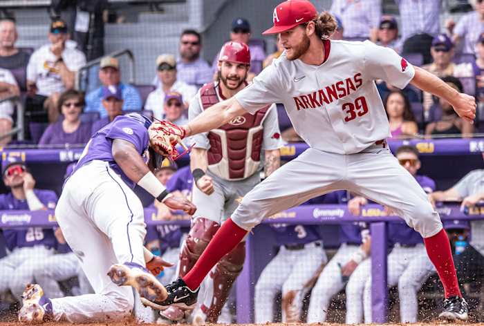 Arkansas pitcher Hunter Hollan applies the tag at the plate in a Game 1 win against LSU in Baton Rouge.