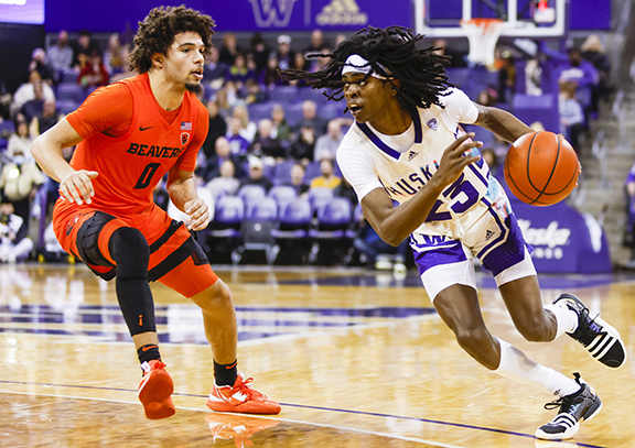 Washington Huskies guard Keyon Menifield dribbles against Oregon State Beavers guard Jordan Pope during the first half at Alaska Airlines Arena.