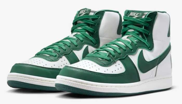 Side view of white and green Nike shoes.