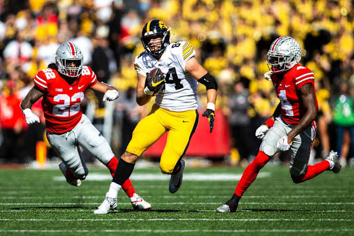Iowa tight end Sam LaPorta (84) runs for extra yards as Ohio State linebacker Steele Chambers (22) and Ohio State cornerback JK Johnson (4) give chase. Joseph Cress/Iowa City Press-Citizen / USA TODAY NETWORK