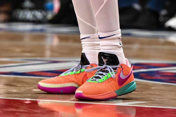 View of orange and green Nike LeBron shoes.