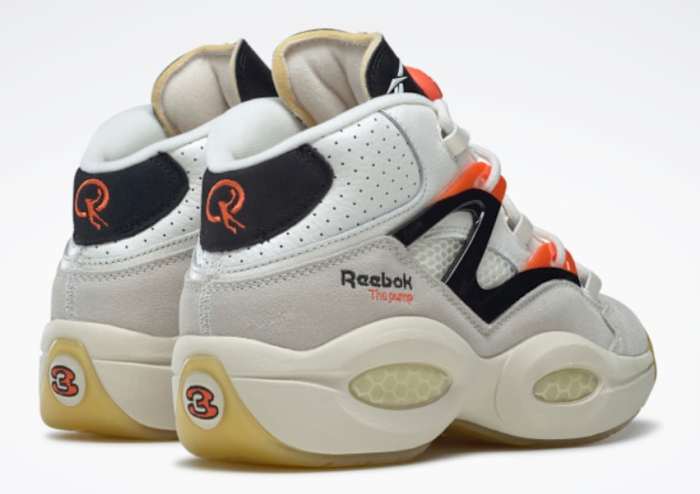Back view of white, black, and orange Reebok shoes.