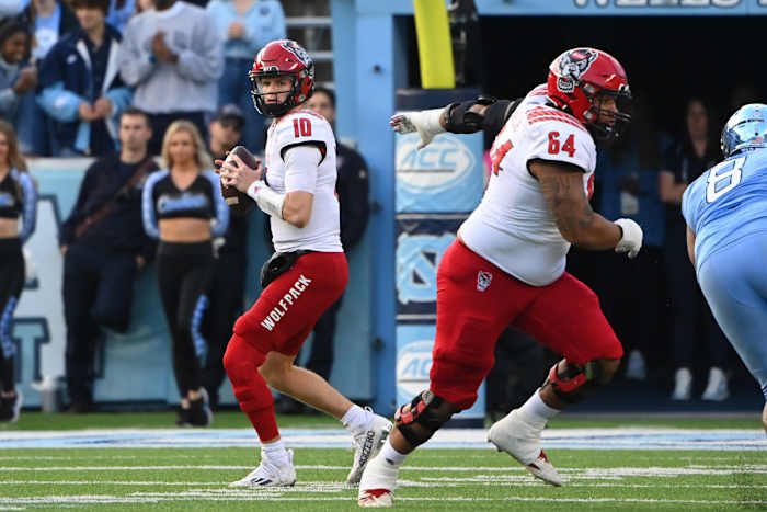 Nov 25, 2022; Chapel Hill, North Carolina, USA; North Carolina State Wolfpack quarterback Ben Finley (10) looks to pass as guard Chandler Zavala (64) blocks and North Carolina Tar Heels defensive lineman Myles Murphy (8) pressures in the first quarter at Kenan Memorial Stadium.