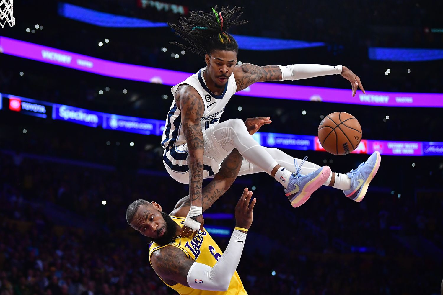 Memphis Grizzlies guard Ja Morant jumps over Los Angeles Lakers forward LeBron James.
