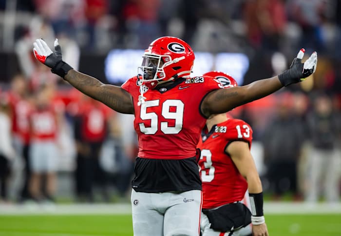 Georgia Bulldogs offensive lineman Broderick Jones holds his hands up and out to the sky