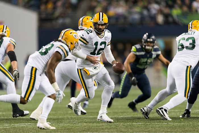Green Bay Packers quarterback Aaron Rodgers hands the ball off to running back Aaron Jones.