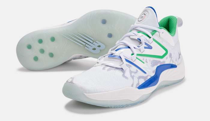 Side view of white, blue, and green New Balance shoes.