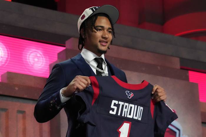 Apr 27, 2023; Kansas City, MO, USA; Ohio State Buckeyes quarterback CJ Stroud (left) poses with jersey after being selected as the No. 2 pick in the first round of the 2023 NFL Draft at Union Station.
