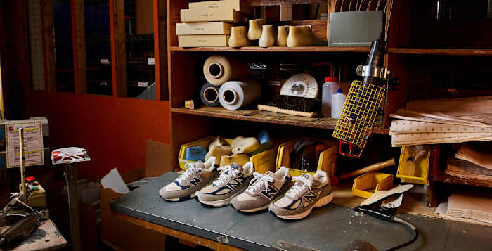 View of four grey New Balance sneakers in a workshop.