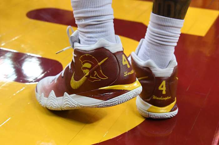 View of cardinal and gold Nike Kyrie shoes.