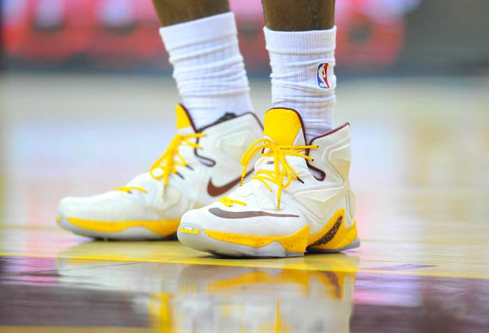 View of white and gold Nike LeBron shoes.