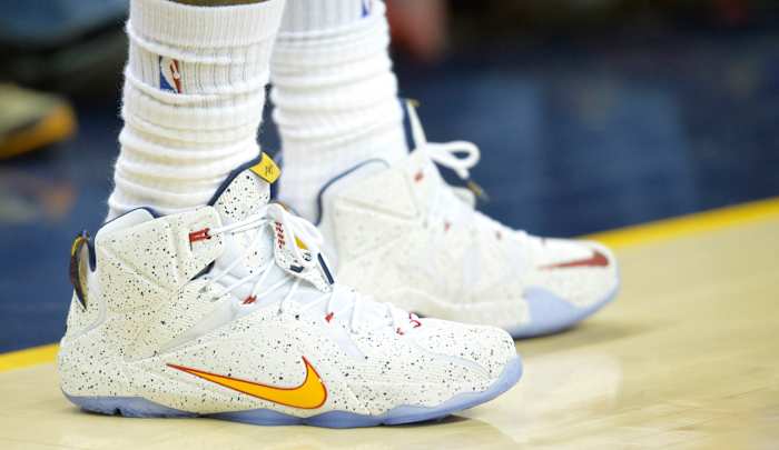 View of white and gold Nike LeBron shoes.