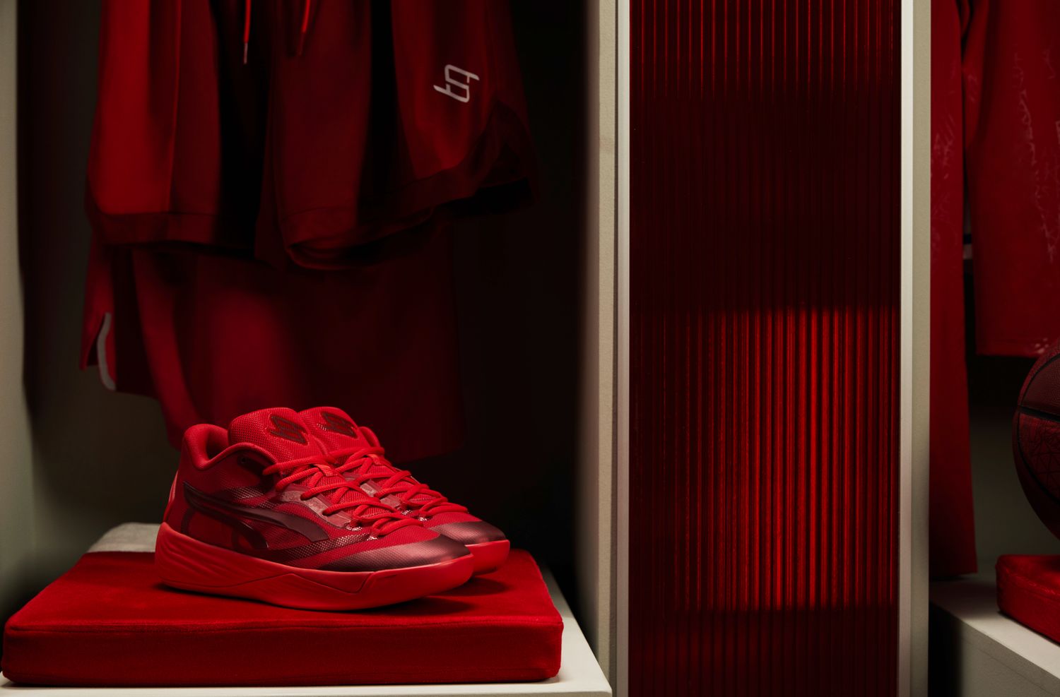 Side view of red Puma basketball shoes.