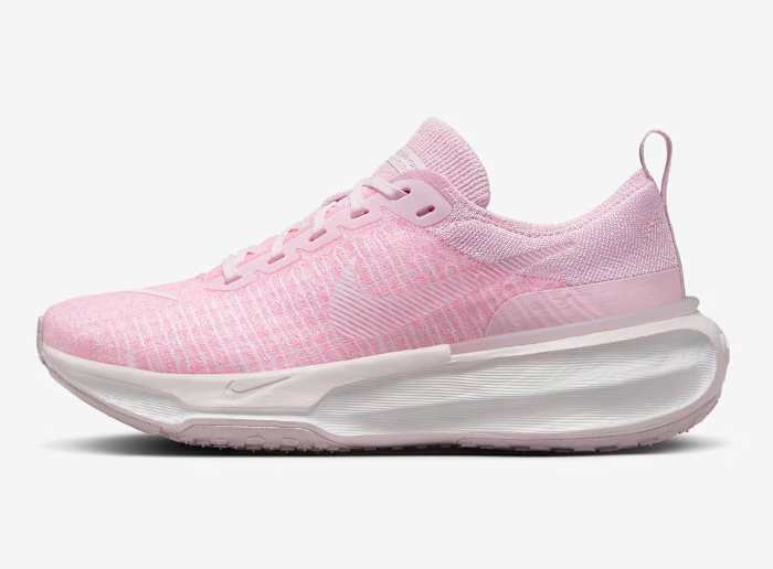 Side view of pink and white Nike running shoe.