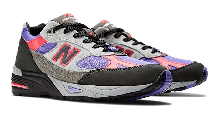 Side view of grey, purple, and black New Balance shoes.