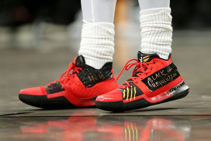 View of Kyrie Irving's red and black Nike shoes.