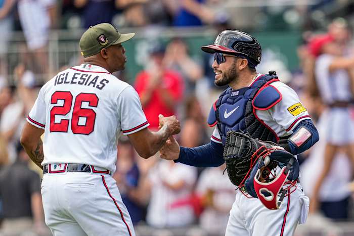 May 21, 2023; Cumberland, Georgia, USA; Atlanta Braves relief pitcher Raisel Iglesias (26) reacts with catcher Travis d'Arnaud (16) after the Braves defeated the Seattle Mariners at Truist Park.