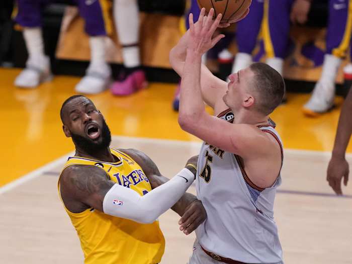 Nuggets center Nikola Jokic shoots the ball against Lakers forward LeBron James during Game 4