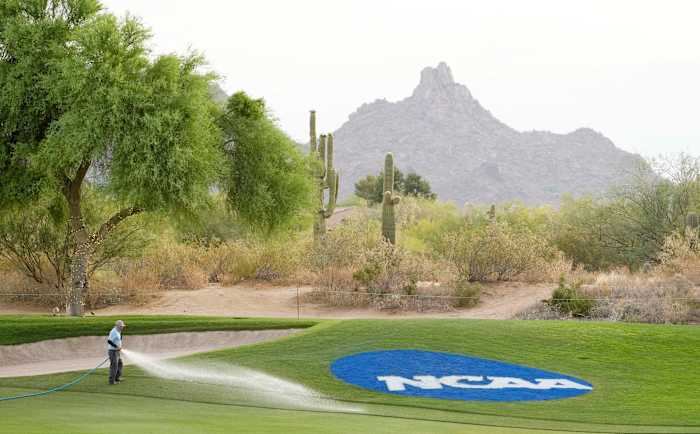 A course worker waters the grass on the 18th fairway at the NCAA Division I Men's Golf Championships at Grayhawk Golf Club - Raptor Course.