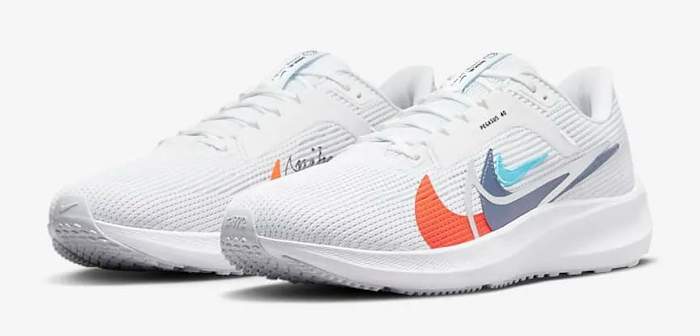 Side view of white and orange Nike running shoes.