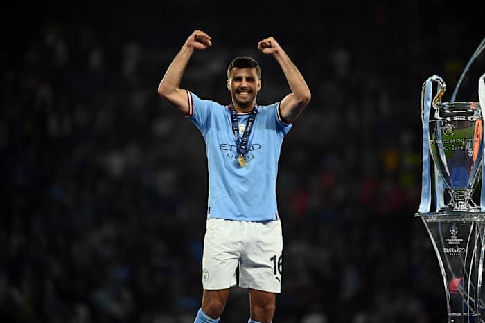 Rodri pictured standing next to the UEFA Champions League trophy after scoring the winning goal for Manchester City in the 2023 final
