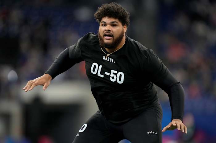 Darnell Wright puts his arms out to the side wearing a black shirt at the combine
