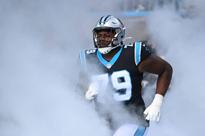 Carolina Panthers offensive tackle Ikem Ekwonu runs on to the field in a cloud of smoke