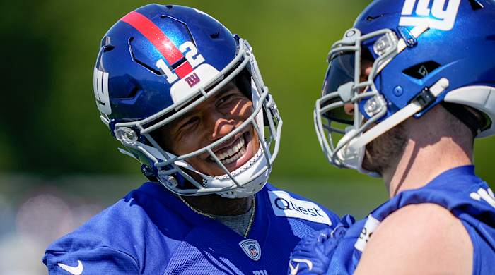 Giants tight ends Darren Waller, left, and Daniel Bellinger, right, laugh on the sidelines of practice.