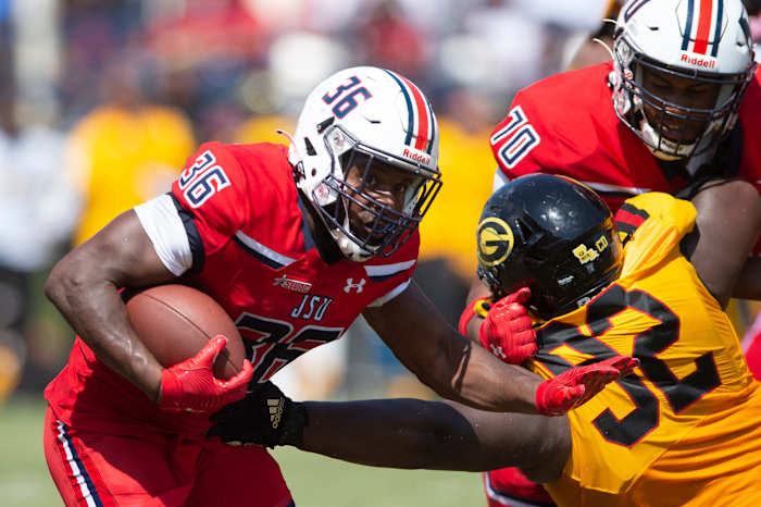 Jackson State running back Sy'veon Wilkerson (26) pushes forward as offensive lineman Kirk Ford (70) holds back Grambling defensive lineman Wesley Green (92) during an NCAA college football game in Jackson, Miss.