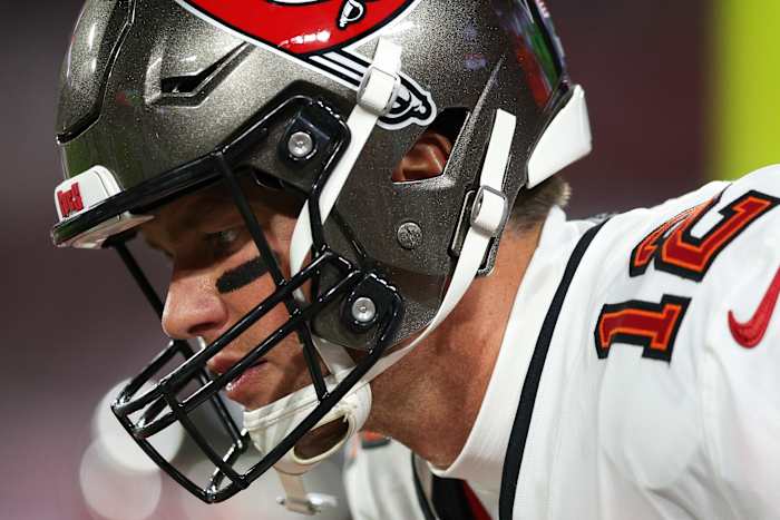 Tom Brady looks down with his helmet on