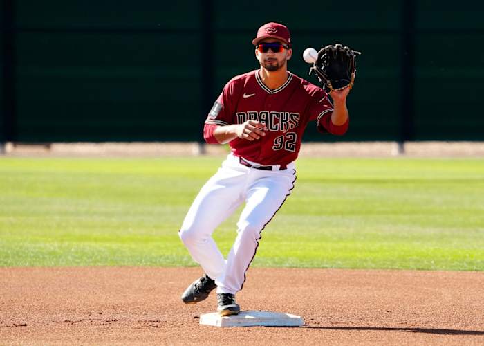 Diamondbacks infielder prospect Jordan Lawlar (92) receives a throw while standing on second base while doing Spring Training drills on a backfield.