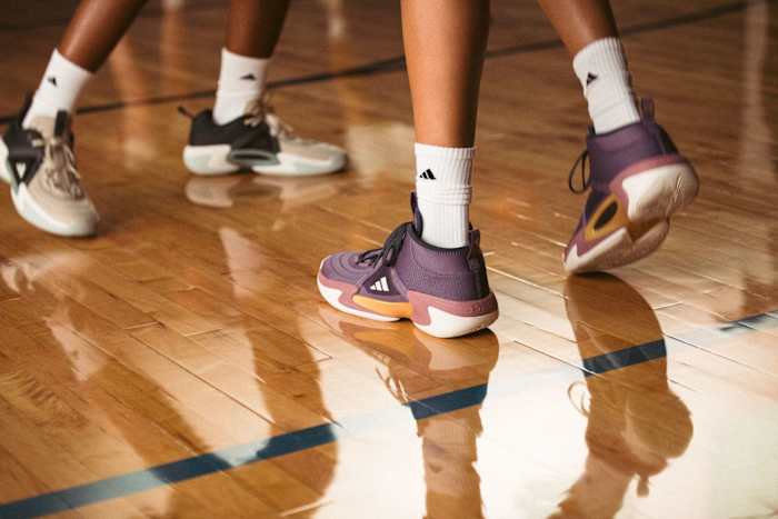View of purple and orange adidas women's basketball shoes.