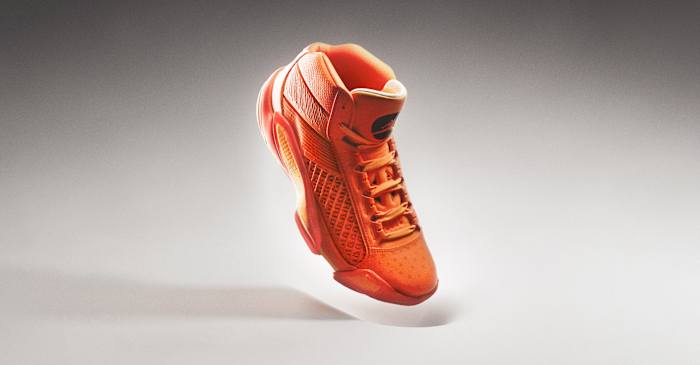 Side view of an orange and black Air Jordan basketball shoe.