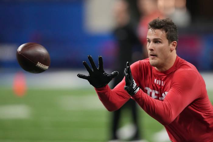 tight end Sam Laporta puts his hands out to catch the ball flying through the air toward him