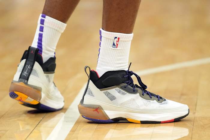 View of Harrison Barnes' white and black Air Jordan basketball shoes.
