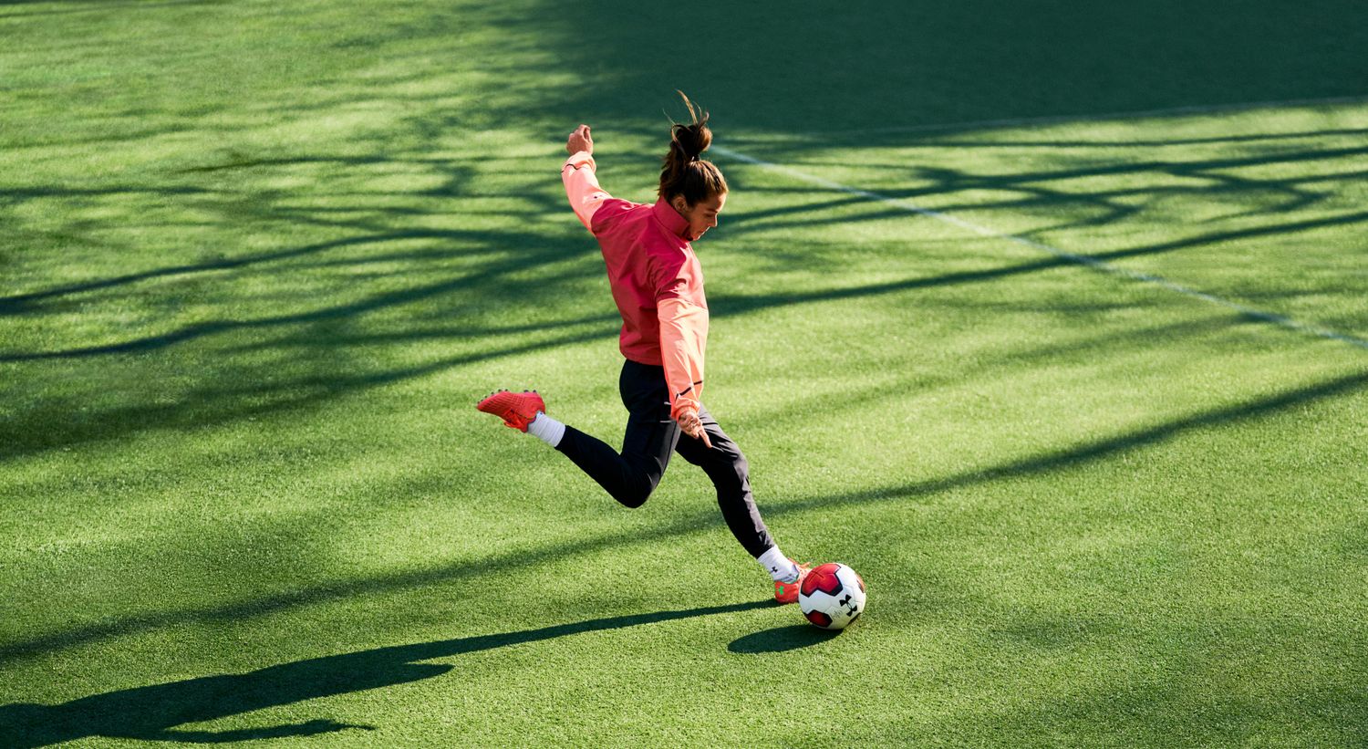Kelley O'Hara kicks a soccer ball.