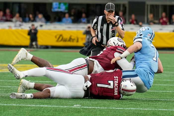 North Carolina Tar Heels quarterback Sam Howell (7) is sacked by South Carolina Gamecocks defensive lineman Zacch Pickens (6) and defensive end Jordan Strachan (7) during the second quarter at Bank of America Stadium. Mandatory Credit: Jim Dedmon-USA TODAY Sports